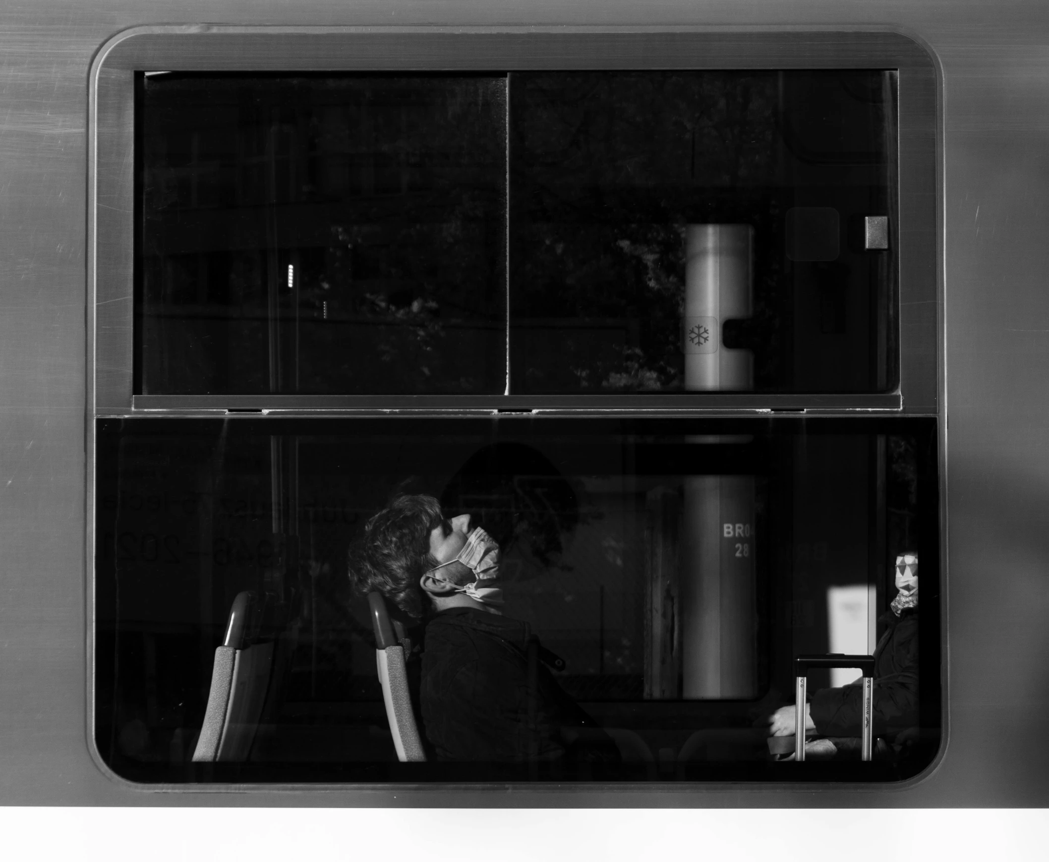 a black and white photo of a woman looking out a window, a black and white photo, by Jan Rustem, view from a news truck, kissing, desk, capsule hotel