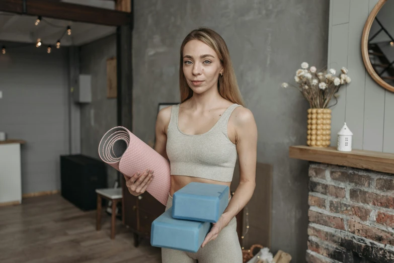 a woman holding a stack of yoga mats, pexels contest winner, happening, avatar image, high quality picture, anna nikonova aka newmilky, attractive face and body