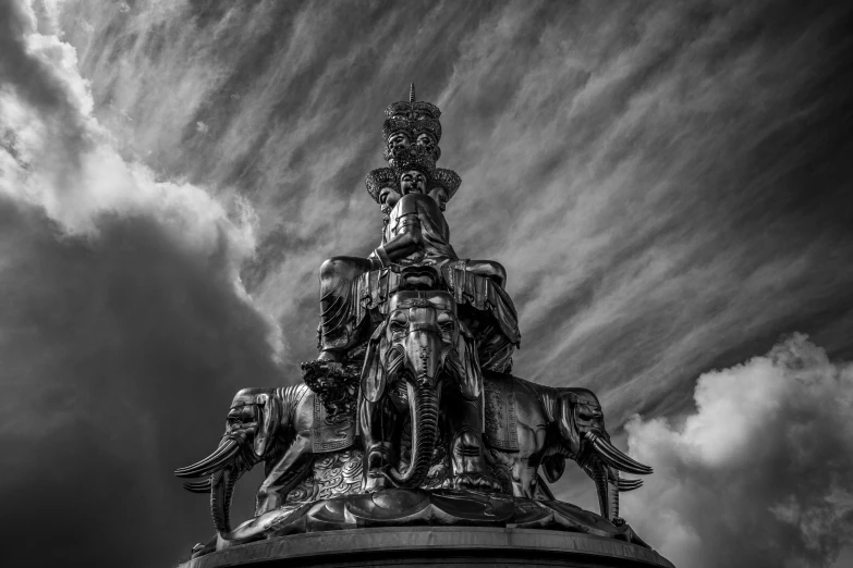 a black and white photo of a statue on top of a building, inspired by Sir Jacob Epstein, unsplash contest winner, baroque, ganesha, with dramatic sky, tusks, hannover