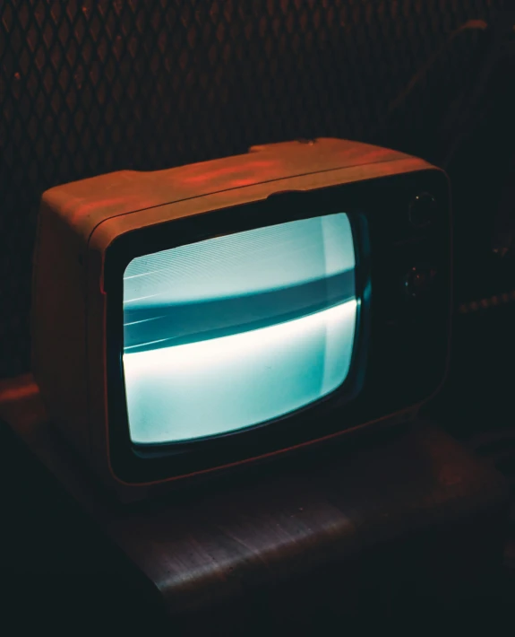 a small television sitting on top of a wooden table, an album cover, inspired by Elsa Bleda, unsplash, thin glowing devices, 1 9 8 0 s photo, ( ( theatrical ) ), profile picture