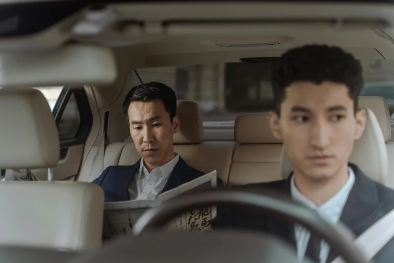 two men sitting in the back seat of a car, an album cover, inspired by Zhang Xiaogang, pexels contest winner, business men, serious expression, [ theatrical ], ismail inceoglu and ruan jia