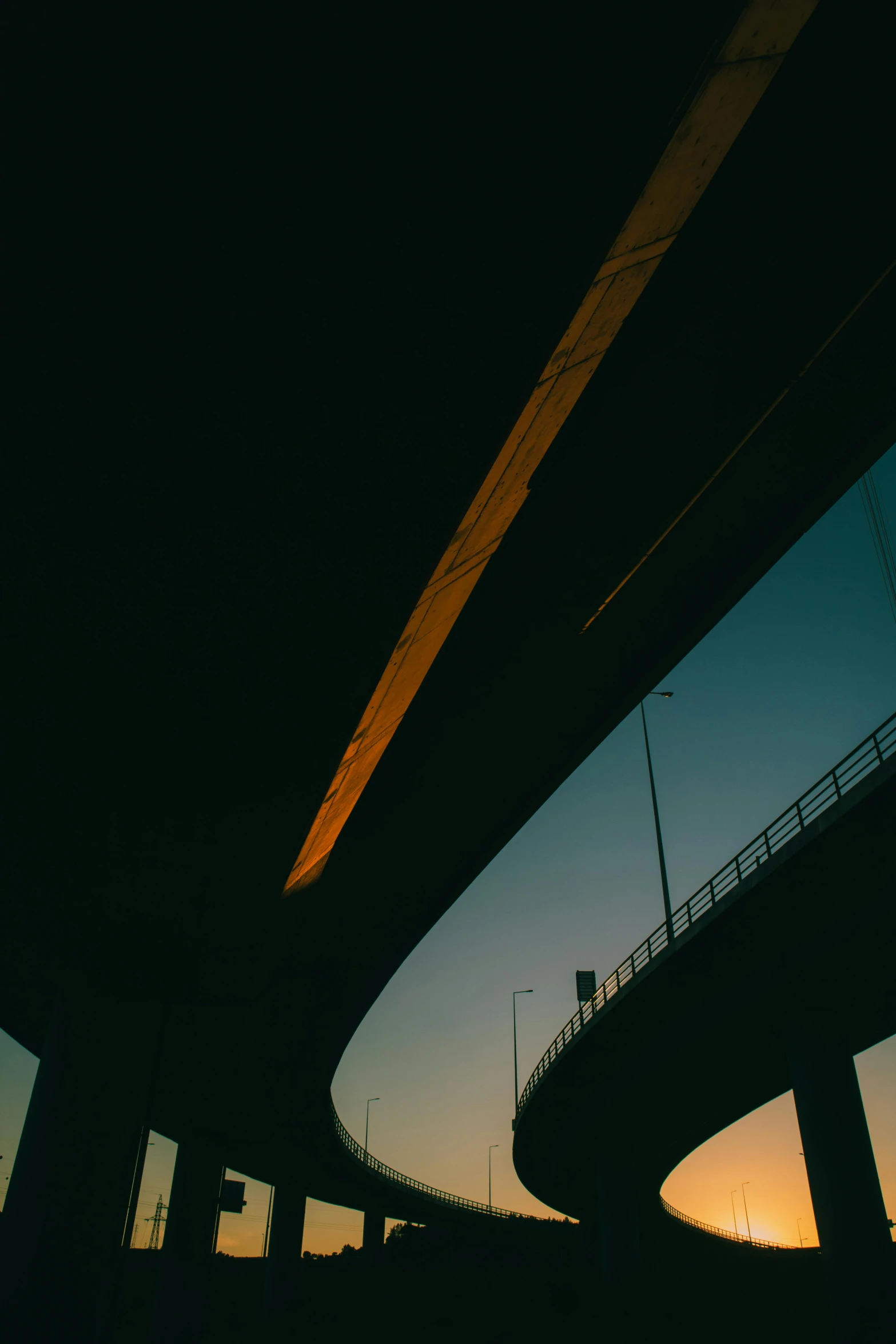 a silhouette of a person riding a skateboard under a bridge, an album cover, unsplash, highways, cars, low quality photo