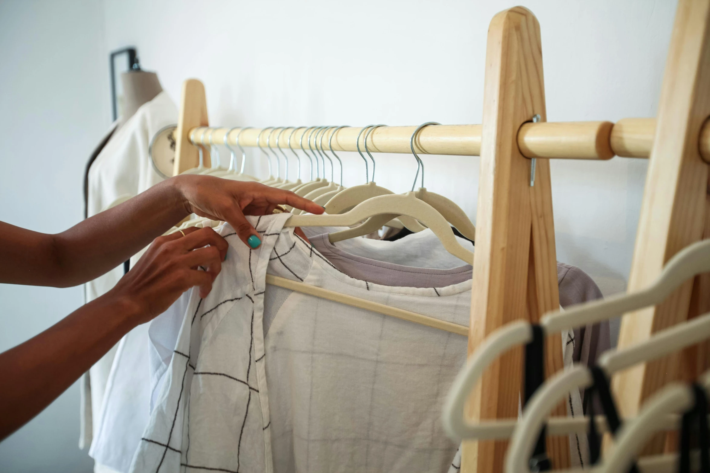 a woman standing in front of a rack of clothes, trending on unsplash, process art, holding a wooden staff, close - up photo, product design shot, slide show