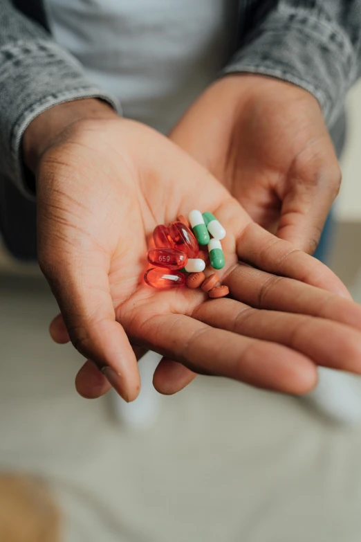 a person holding a handful of pills in their hand, by Sebastian Vrancx, pexels, multiple stories, colored photo, riyahd cassiem, schools