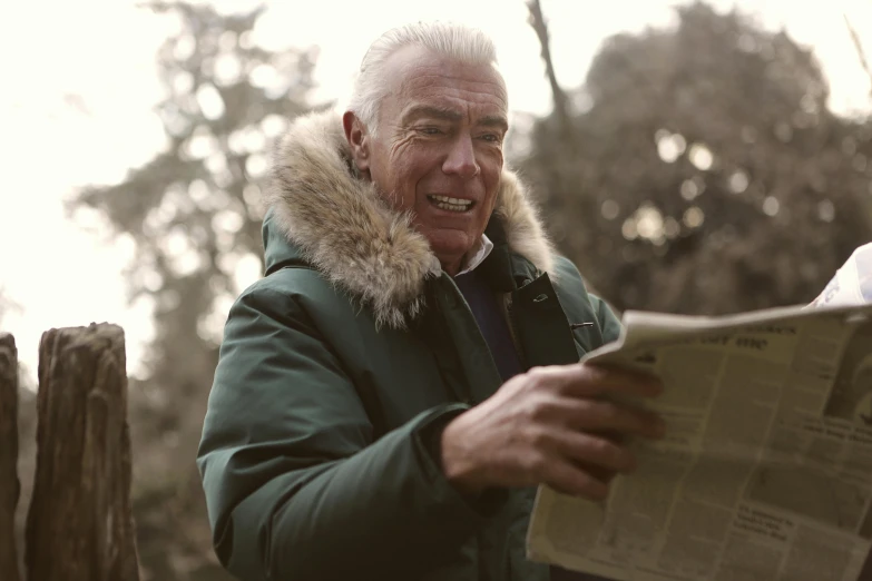 a man in a parka reading a newspaper, a photo, pexels contest winner, ric flair, enjoying a stroll in the forest, filmstill, grandfatherly