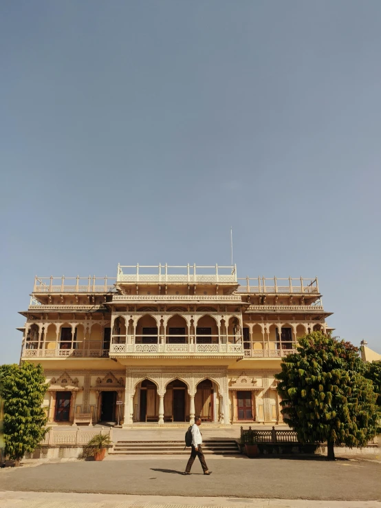 a man walking in front of a large building, in balcony of palace, hindu aesthetic, snapchat photo, fan favorite