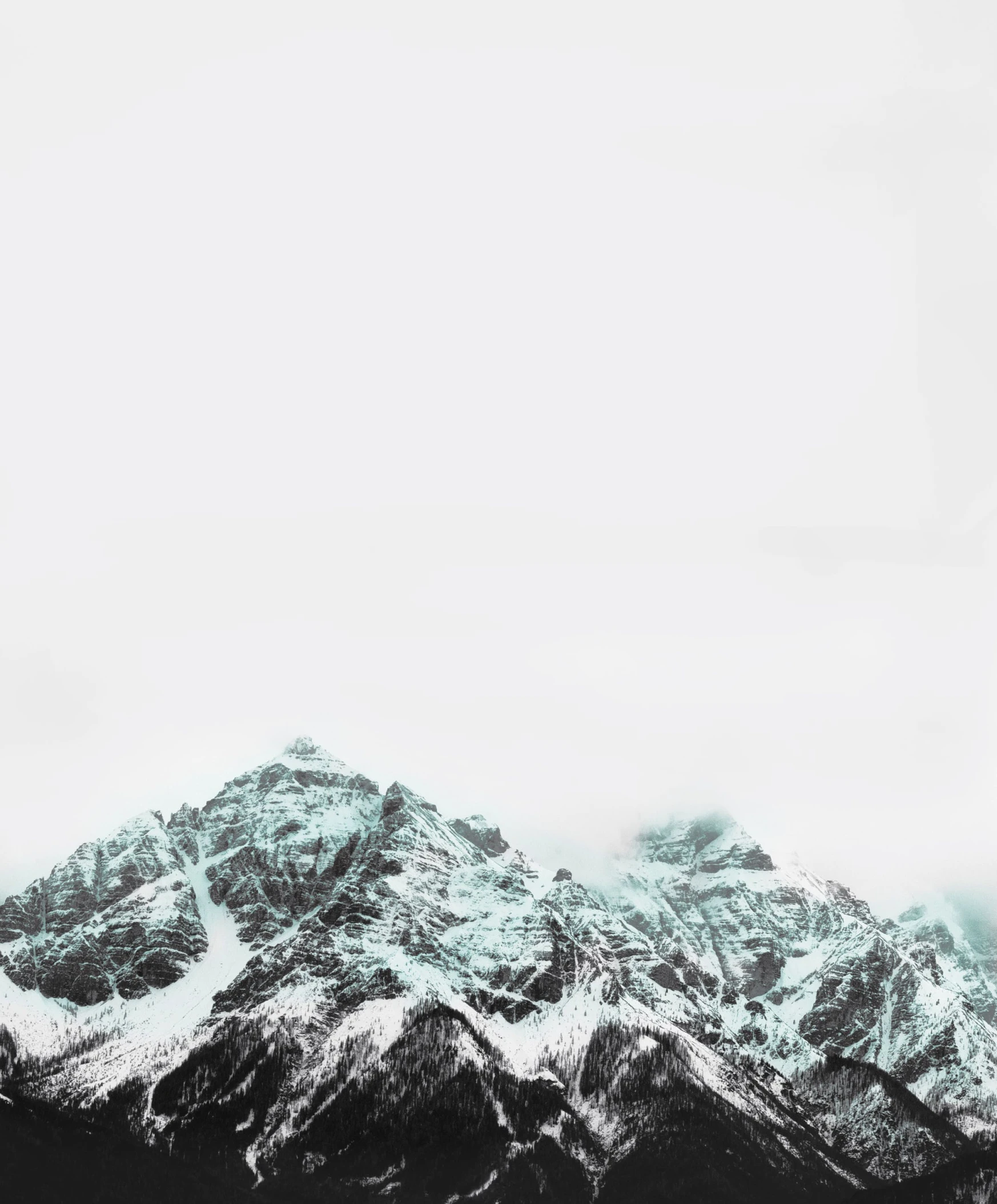 a black and white photo of a mountain range, an album cover, by Adam Marczyński, trending on unsplash, minimalism, teal aesthetic, snow fall, 8k vertical wallpaper, ultra - realism