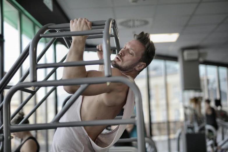 a man is doing a pull up in a gym, by Matija Jama, happening, avatar image, maintenance photo, extremely graphic, chemistry