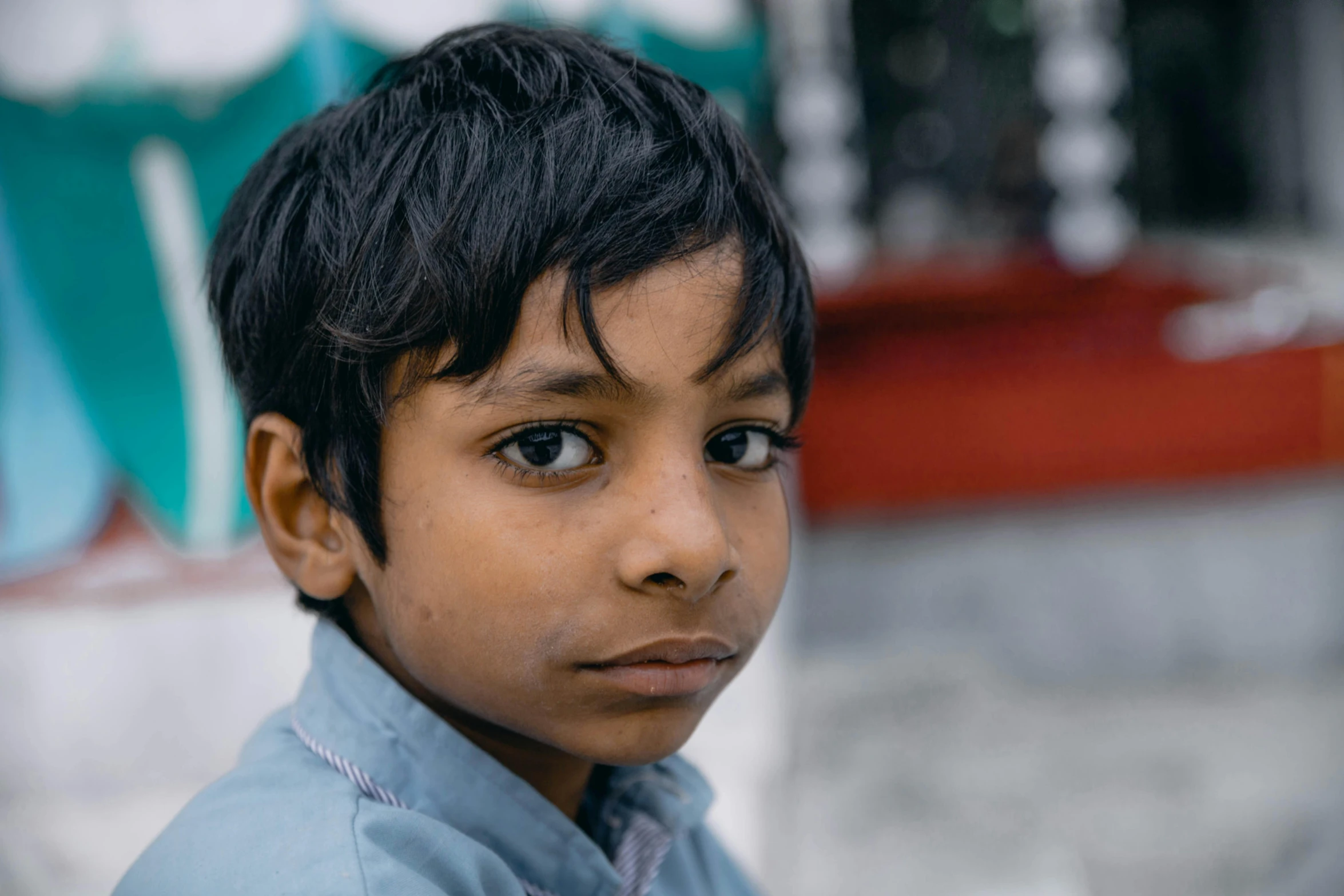 a young boy in a blue shirt looking at the camera, pexels contest winner, kalighat, looking to his left, ignant, student