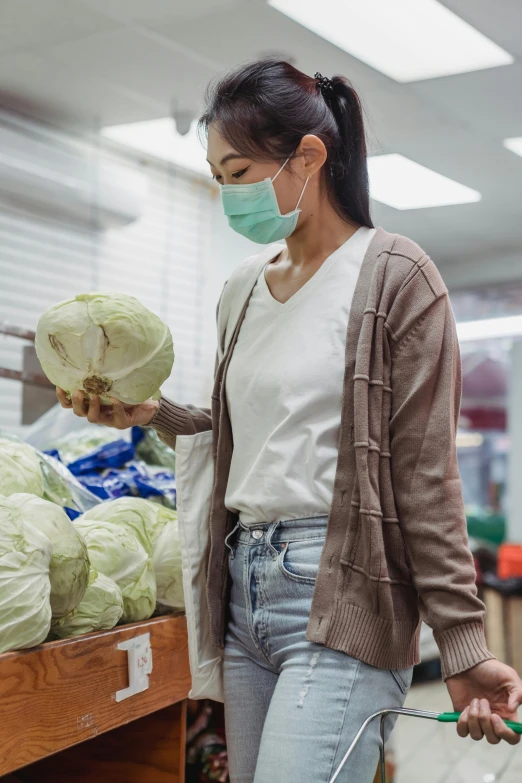 a woman wearing a face mask while shopping in a grocery store, by Jang Seung-eop, pexels, hyperrealism, lettuce, made of lab tissue, myanmar, wearing a crop top