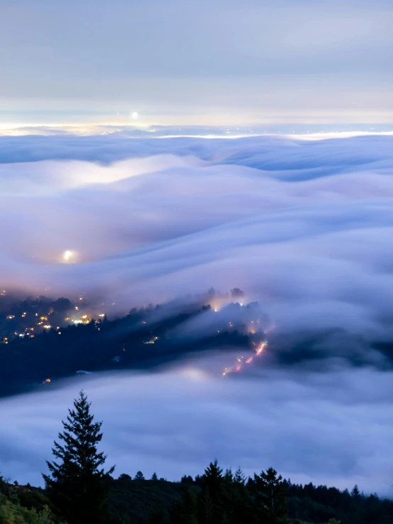 a view of a city from the top of a hill, by Neil Blevins, pexels contest winner, romanticism, above low layered clouds, pacific northwest, mystical night, today\'s featured photograph 4k