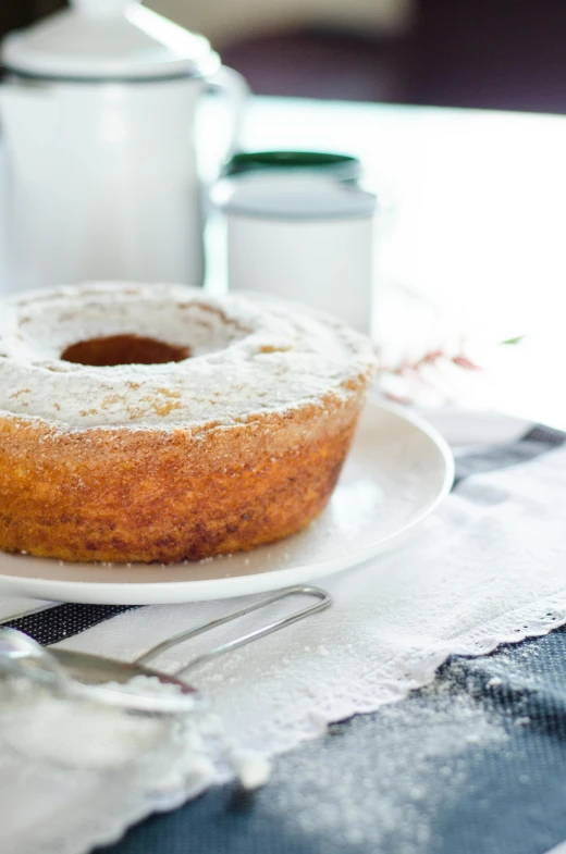 a white plate topped with a donut covered in powdered sugar, by Nicolette Macnamara, cake, pasta, soft shade, linen