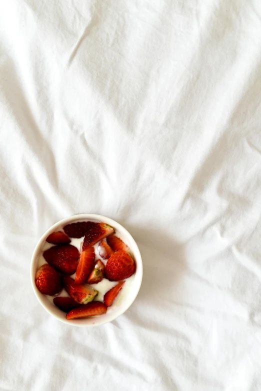 a bowl of strawberries sitting on top of a bed, by Emily Shanks, minimalism, soup, white, flax, infinite