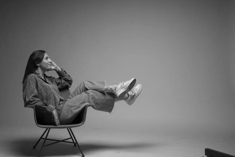 a black and white photo of a man sitting in a chair, inspired by Sarah Lucas, pexels, conceptual art, girl in studio, at behance, casual pose, carl sagan