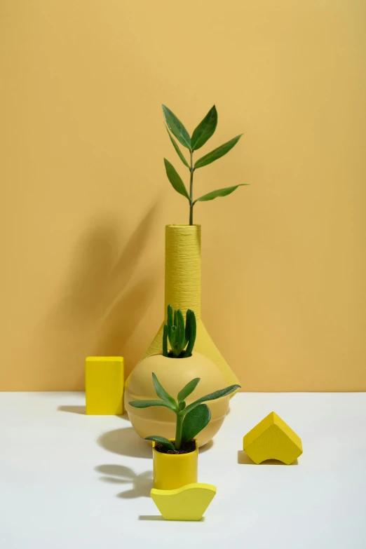 a yellow vase sitting on top of a white table, inspired by Giorgio Morandi, modernism, building cover with plant, detailed product shot, full object in middle, architectural and tom leaves