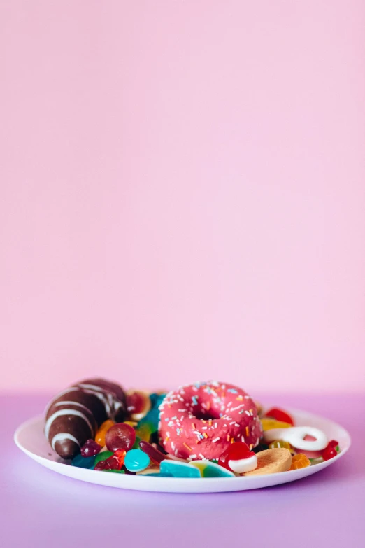 a plate of assorted donuts on a pink background, a still life, by Winona Nelson, pexels, made of candy, cereal, boys, minn