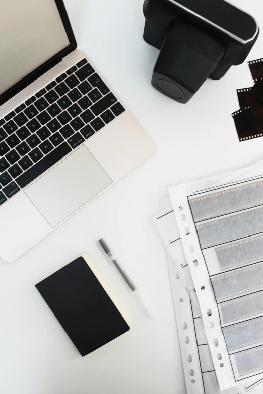 a laptop computer sitting on top of a white desk, a black and white photo, trending on unsplash, film artifacts, platinum printing, design on a white background, high angle close up shot