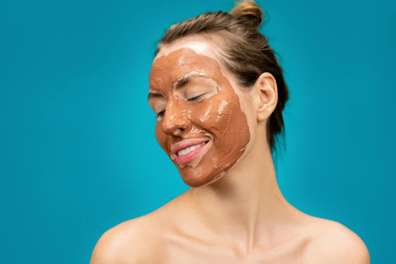 a woman with a mud mask on her face, trending on pexels, antipodeans, terracotta, brown, right - half a cheerful face, chocolate