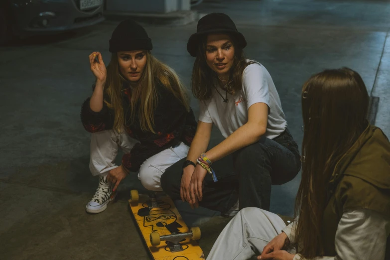 a group of young women sitting on top of a skateboard, pexels contest winner, wearing a baseball hat, indoor shot, artststion, three women