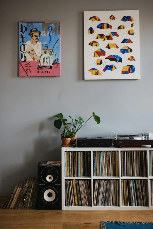 a record player sitting on top of a wooden floor, an album cover, trending on unsplash, funk art, plants on pots and on the walls, spiral shelves full of books, candid portrait photo, photo of a painting
