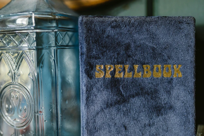 a close up of a book on a table, an album cover, by Sylvia Wishart, unsplash, blue robes, speakeasy, the poolrooms, spellbreak