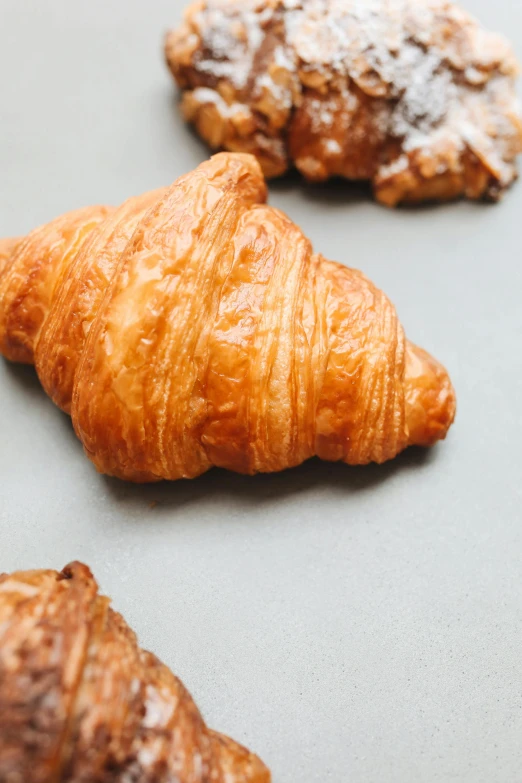 a couple of croissants sitting on top of a table, on a gray background, slide show