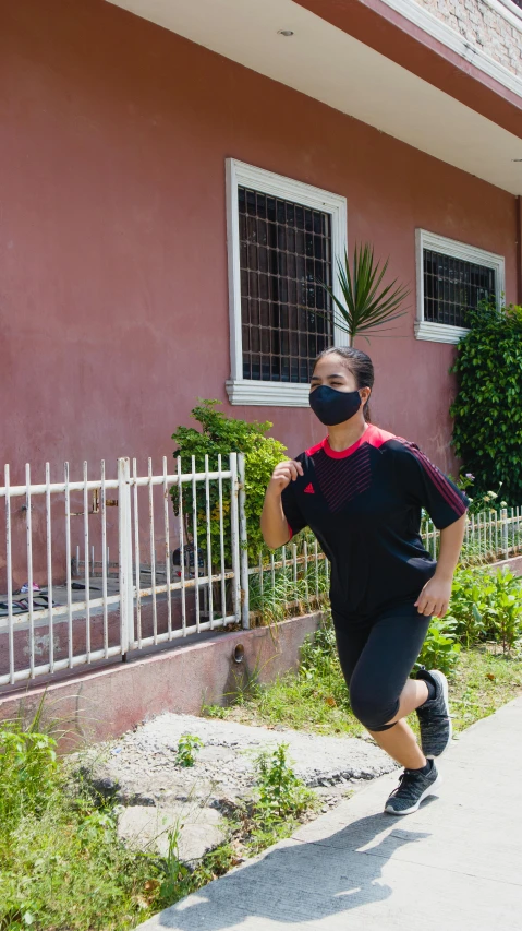 a man running down a sidewalk in front of a house, black facemask, manila, a young asian woman, 15081959 21121991 01012000 4k