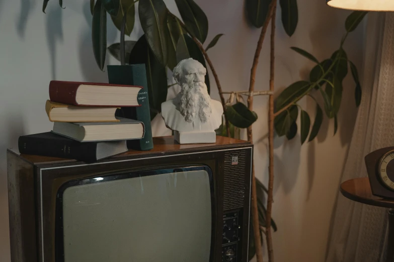 a small television sitting on top of a wooden table, a statue, inspired by Elsa Bleda, trending on pexels, video art, 1 9 8 0 s photo, porcelain holly herndon statue, studious chiaroscuro, 1980s photo