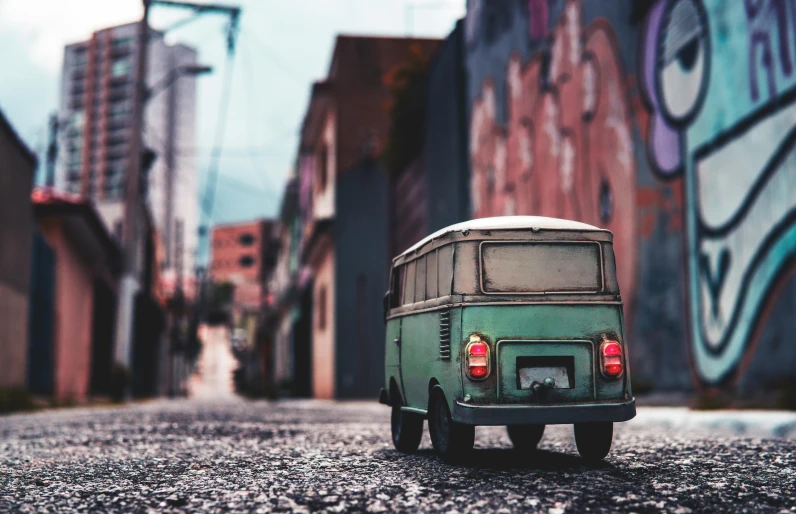 a small green van parked on the side of a road, by Elsa Bleda, pexels contest winner, photorealism, miniature city, mexico city, vintage old, built on a small