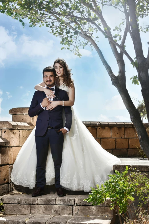 a man in a tuxedo hugging a woman in a wedding dress, a portrait, by Arthur Sarkissian, instagram, in a scenic background, assyrian, high-resolution photo, commercially ready