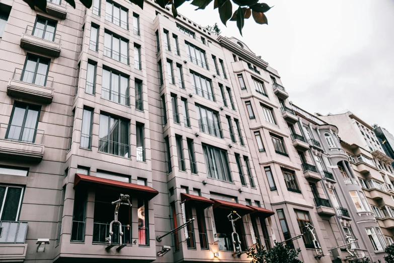 a very tall building with lots of windows, inspired by Albert Paris Gütersloh, unsplash, art nouveau, awnings, 2 0 0 0's photo, square, paris hotel style