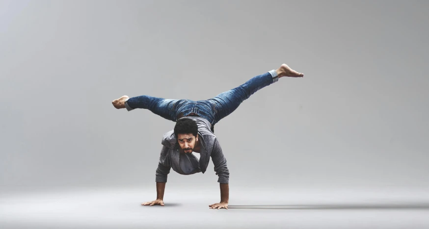 a man doing a handstand on a gray background, inspired by Graham Forsythe, pexels contest winner, arabesque, a portrait of rahul kohli, various action poses, breakdancing, lizard pose