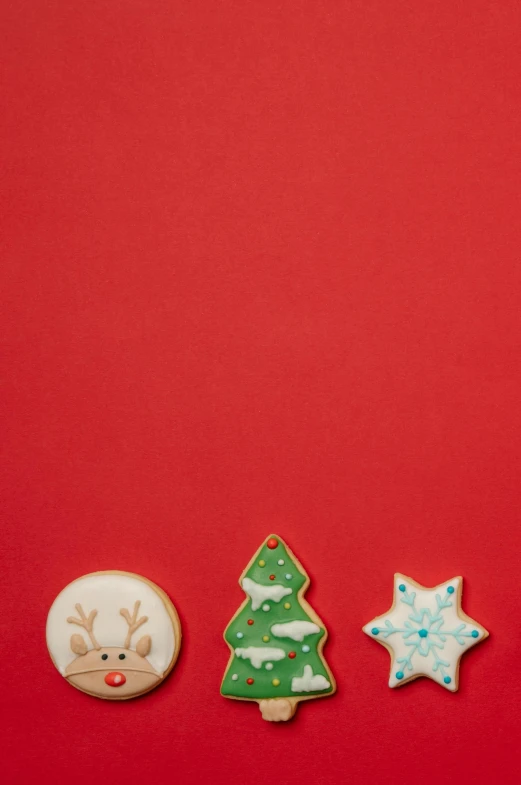 a group of christmas cookies sitting on top of a red surface, by Paul Bird, 3 - piece, ornaments, no text!, diverse