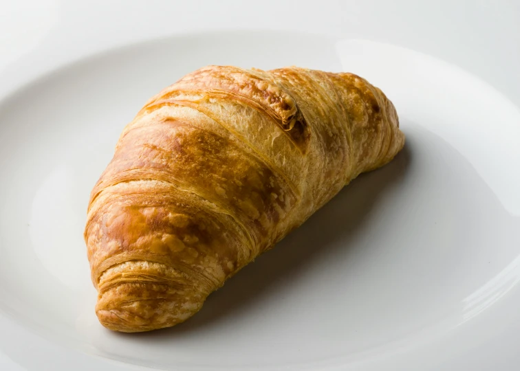 a croissant on a white plate on a table, 6 pack, fan favorite, petite, long