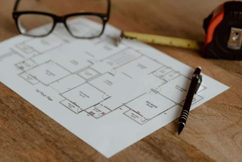 a pair of glasses sitting on top of a piece of paper, a detailed drawing, unsplash, floor plan, built on a small, middle close up, modeled