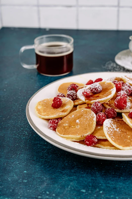 a plate of pancakes with raspberries and powdered sugar, 6 pack, fan favorite, medium - shot, coast