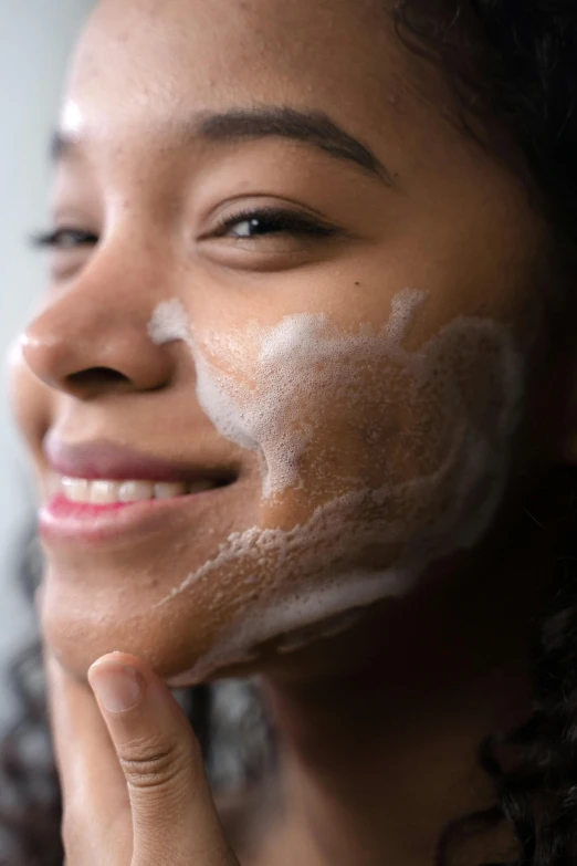 a woman with a lot of cream on her face, a stipple, trending on pexels, foam, side portrait imagery, looking happy, product shot