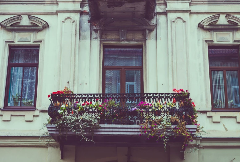 a balcony that has a bunch of flowers on it, pexels contest winner, art nouveau, the place is just really small, gothic aesthetic, stalinist architecture, vintage photo