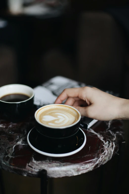 a person sitting at a table with two cups of coffee, melbourne, fan favorite, black, vanilla