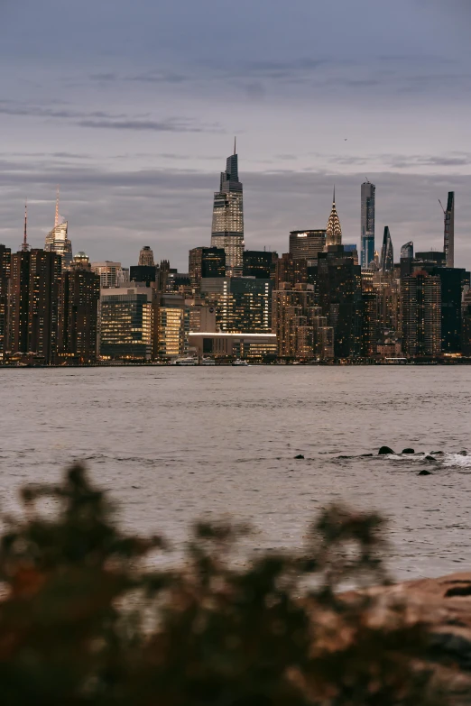 a large body of water with a city in the background, by Jacob Burck, unsplash contest winner, hudson river school, 8k 50mm iso 10, late summer evening, viewed from the harbor, city views