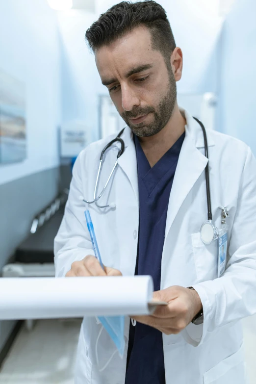 a man in a lab coat writing on a piece of paper, lgbtq, surgical gown and scrubs on, multiple stories, uploaded