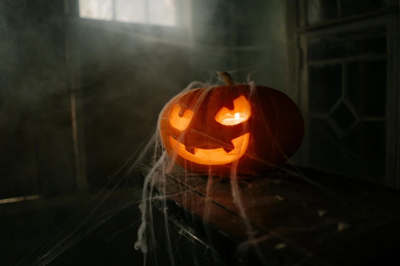 a halloween pumpkin sitting on top of a table, a picture, pexels contest winner, covered with cobwebs and dust, ☁🌪🌙👩🏾, opening shot, rectangle