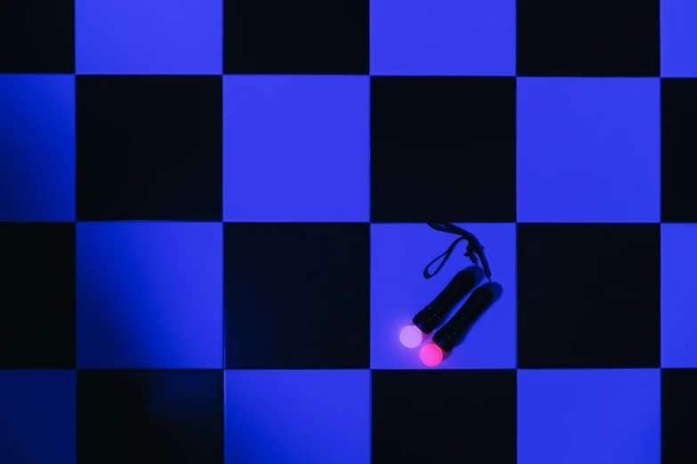 a red light sitting on top of a checkered floor, inspired by Patrick Caulfield, unsplash, black and blue and purple scheme, drag light bombs, torches on wall, high angle close up shot