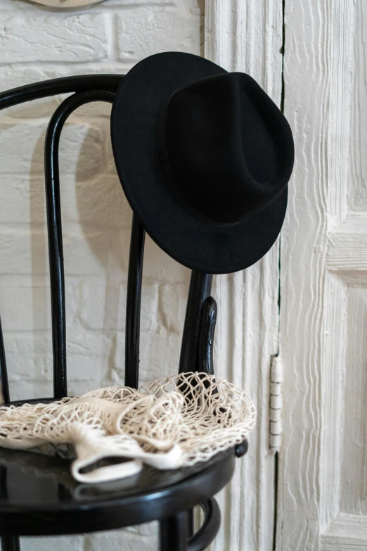 a black chair with a hat on top of it, inspired by Ramon Pichot, unsplash, renaissance, cottagecore, lots de details, dressed in a worn, a quaint