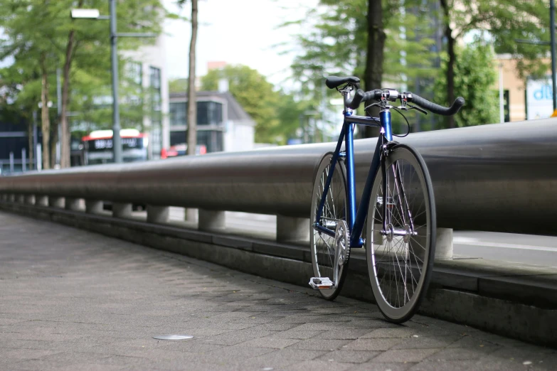 a bicycle leaning against a rail on a city street, blue and silver, in neotokyo, paved, facebook post