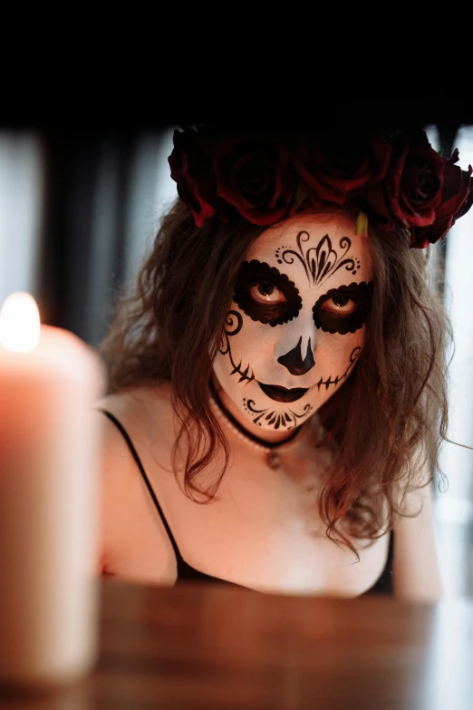 a woman sitting at a table with a candle in front of her, pexels contest winner, gothic art, facepaint facepaint facepaint, square, mexican, black roses in hair