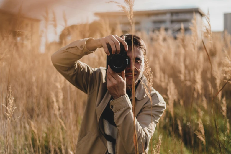 a man taking a picture in a field of tall grass, pexels contest winner, front facing the camera, avatar image, outdoor photo, candid flash photography