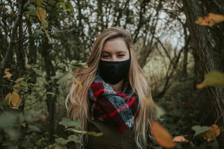 a woman wearing a face mask in the woods, by Emma Andijewska, pexels contest winner, black bandana mask, wearing fluffy black scarf, a girl with blonde hair, in the countryside
