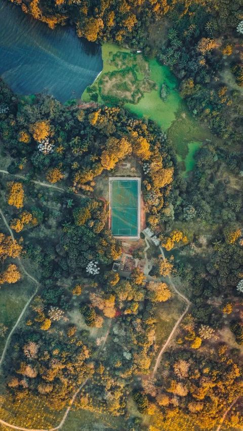 an aerial view of a tennis court surrounded by trees, by Sebastian Spreng, unsplash contest winner, parks and lakes, 15081959 21121991 01012000 4k, instagram post, brown