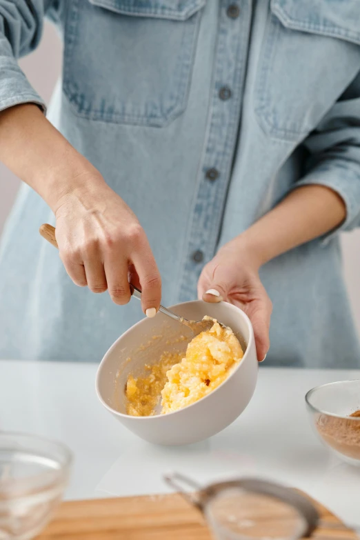 a woman mixing ingredients in a bowl on a table, trending on pexels, butter, dynamic action shot, tall, close together